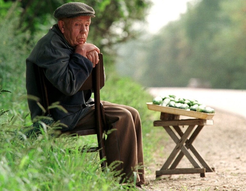 Пенсионер продает огурцы на дороге, 6 августа 1998 года.