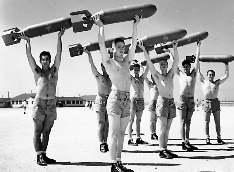 Ежедневная утренняя зарядка американских лётчиков со 100-фунтовыми бомбами. США. 1943 год.
