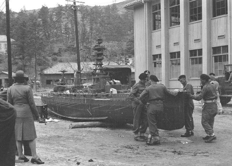 Бойцы кавалерийской дивизии 2NZEF осматривают поврежденную модель японского линкора "Ямасиро" у военно-морской академии Этадзима, 1946 год.