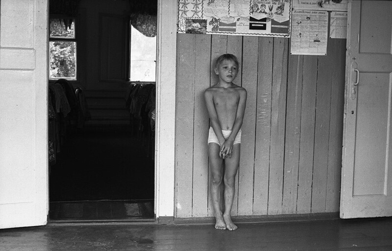 Наказание. В тихий час наказаный за проступок мальчик стоит на веранде спального корпуса. Спортивный лагерь Металлург, 1979.