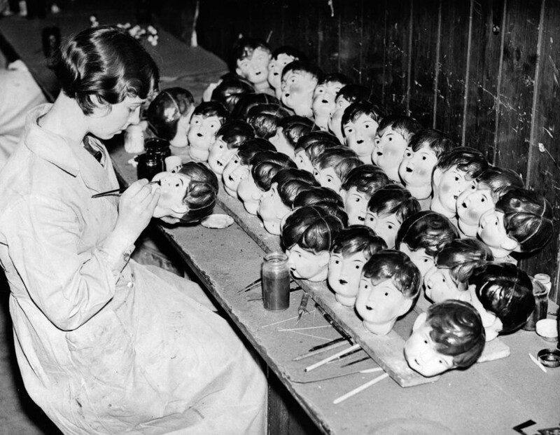 18 декабря 1935 год. Работница раскрашивает целлулоидные кукольные головы на заводе в Англии.