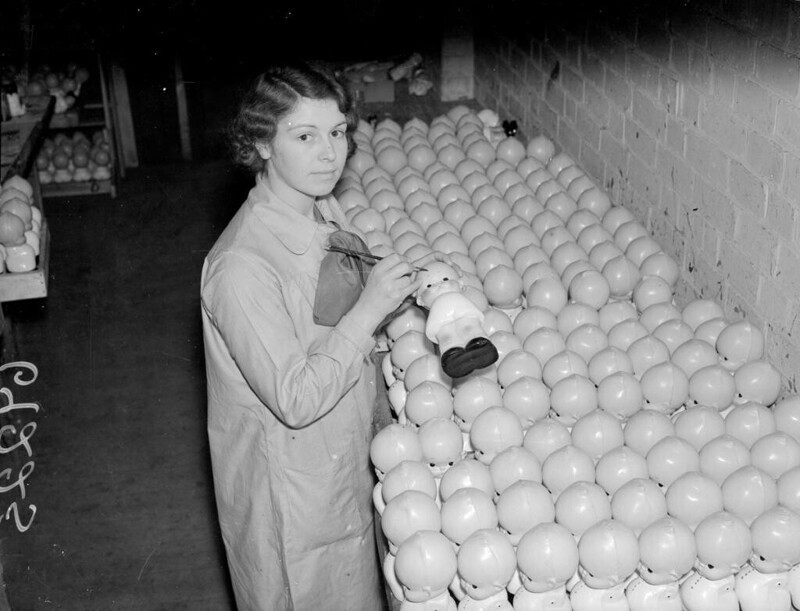 1937 год. Работница разрисовывает кукол на заводе в Англии.