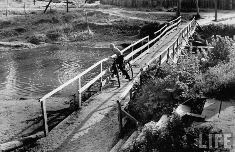 Мальчик смотрит с моста на реку