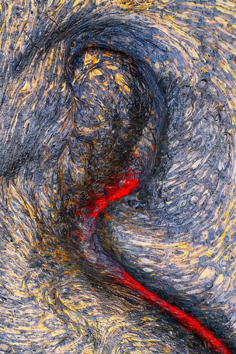 Поток лавы, извергающийся у ног фотографа во время похода по лавовому полю Калапана на Гавайях. Автор: Марк Джеймс