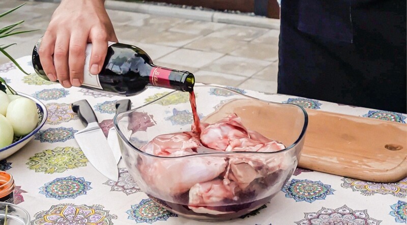 Подготовленные окорочка поместил в глубокое блюдо и залил бутылкой красного сухого вина. Если под рукой окажется гранатовое вино, можете смело его использовать. 