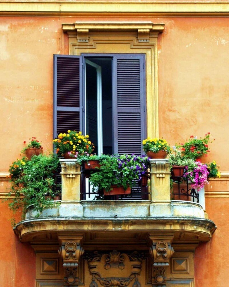  Классический итальянский балкон, украшенный цветами и зеленью.