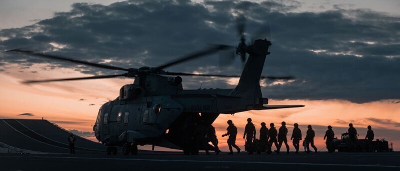 Королевские морские пехотинцы садятся в вертолет Merlin во время учений палубе авианосца HMS Queen Elizabeth. (Фото Kyle Heller):