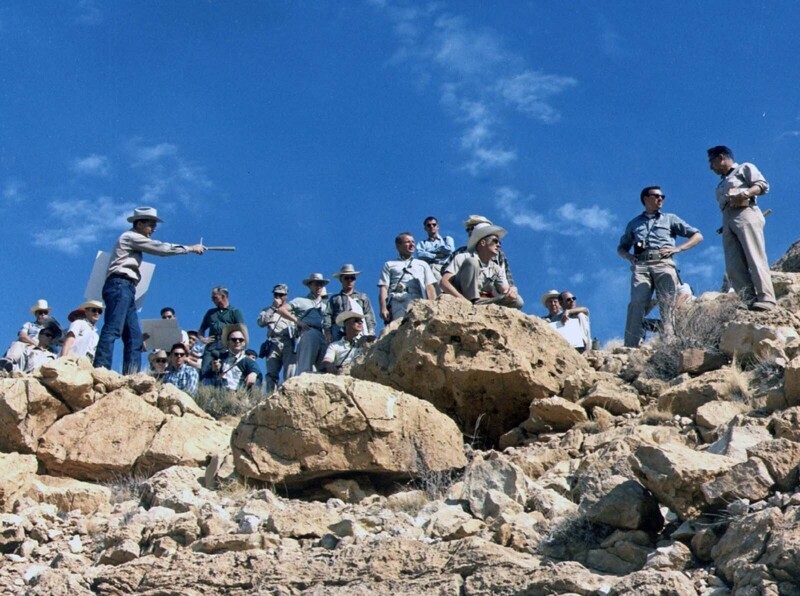 Астрогеолог Джин Шумейкер описывает геологию краевого выброса метеоритного кратера в Аризоне большой группе астронавтов во время полевых учений в мае 1967 года