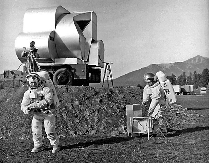Геологи Тим Хейт и Дэвид Шлейхер в скафандрах во время первых полевых испытаний на кратерном поле Синдер-Лейк №1. На заднем плане - имитация модели подъемной ступени лунного модуля