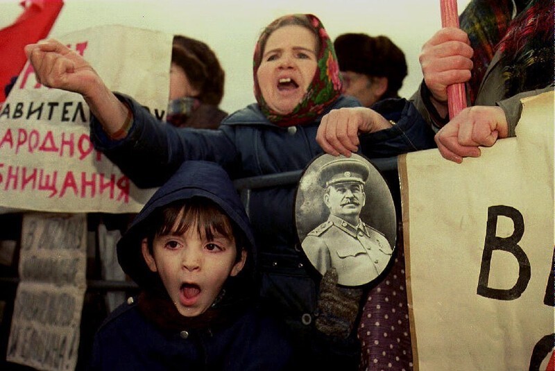 1992. 7 декабря. Женщина держит фотографию Иосифа Сталина, когда выкрикивает лозунги против президента России Бориса Ельцина депутатам, идущих в Кремль для участия в Съезде народных депутатов.