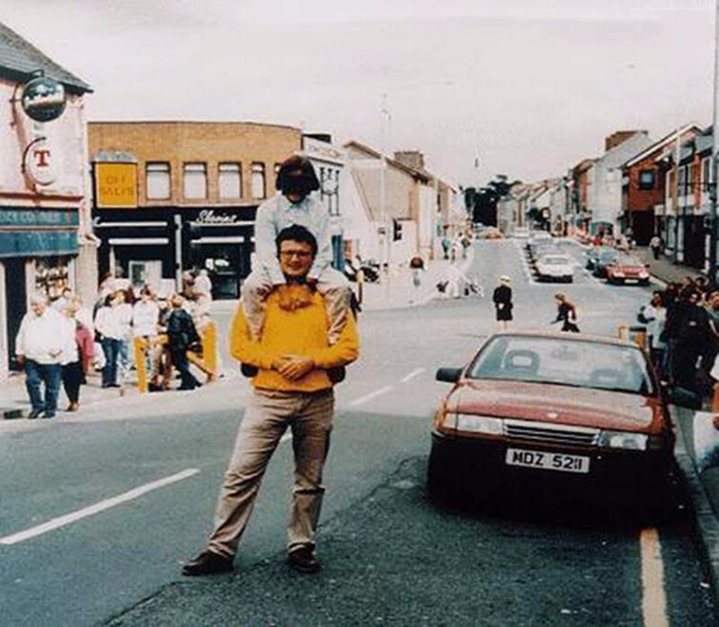 Красная машина на этом фото начинена взрывчаткой. Через несколько минут после фото она взорвалась. В теракте, произошедшем в ирландском Оме в 1998 году, погибло 29 человек и 220 получили ранения. Мужчине с ребенком удалось выжить, фотографу нет.
