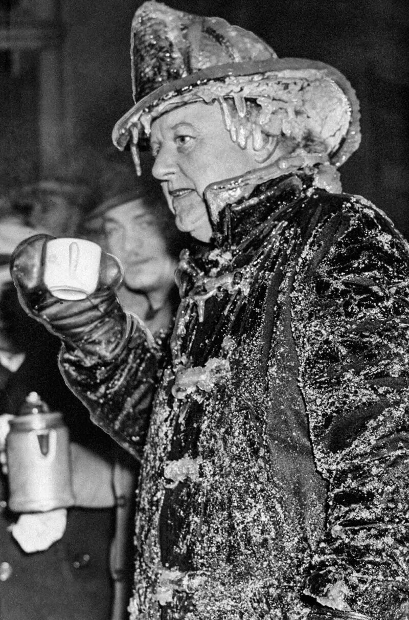 Командир 35-го батальона пожарного департамента Нью-Йорка Уильям Трэверс отогревается чашкой кофе. 1942 г.