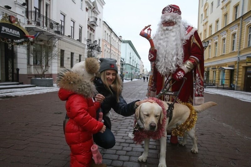 На улицах Нижнего Новгорода Дедушка Мороз с собакой-поводырем вручал подарки всем, кто к нему подходил
