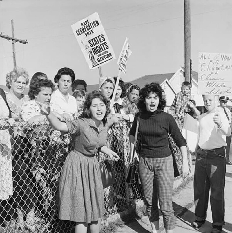  У мальчика в руках плакат «Всё, что я хочу на Рождество — чистую белую школу». Протесты после того, как темнокожая девочка Руби Бриджес первой начала посещать школу для белых, 1960 год.