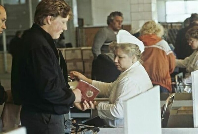 Кассир проверяет у покупателя наличие московской прописки при продаже дефицитного товара. Москва, 1990 год.