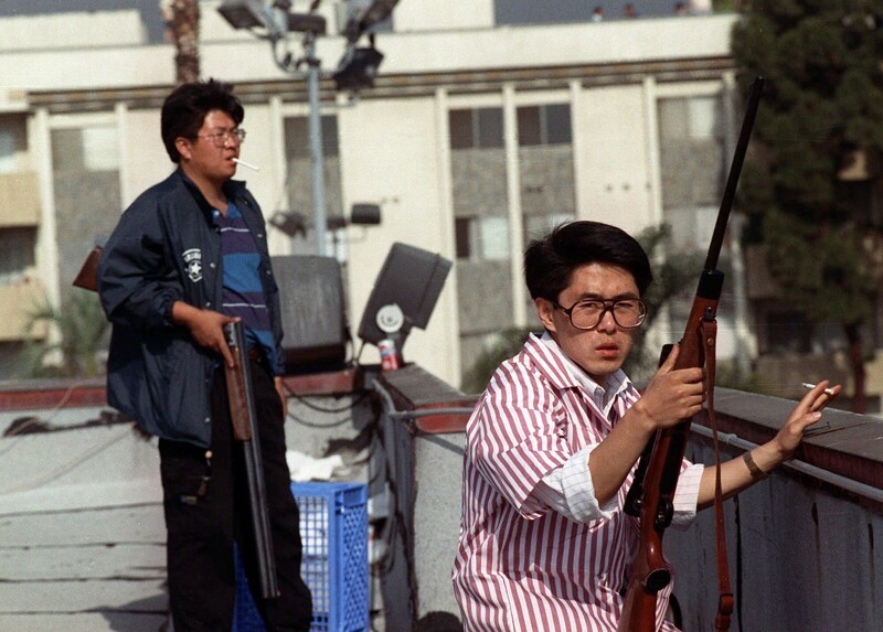 Двое вооружённых винтовками корейцев охраняют продуктовый магазин от нашествия мародёров. Массовые беспорядки в Лос-Анджелесе, 30 апреля, 1992 год