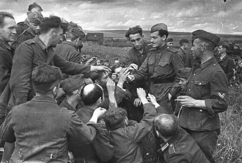 Советский боец угощает куревом немецких военнопленных