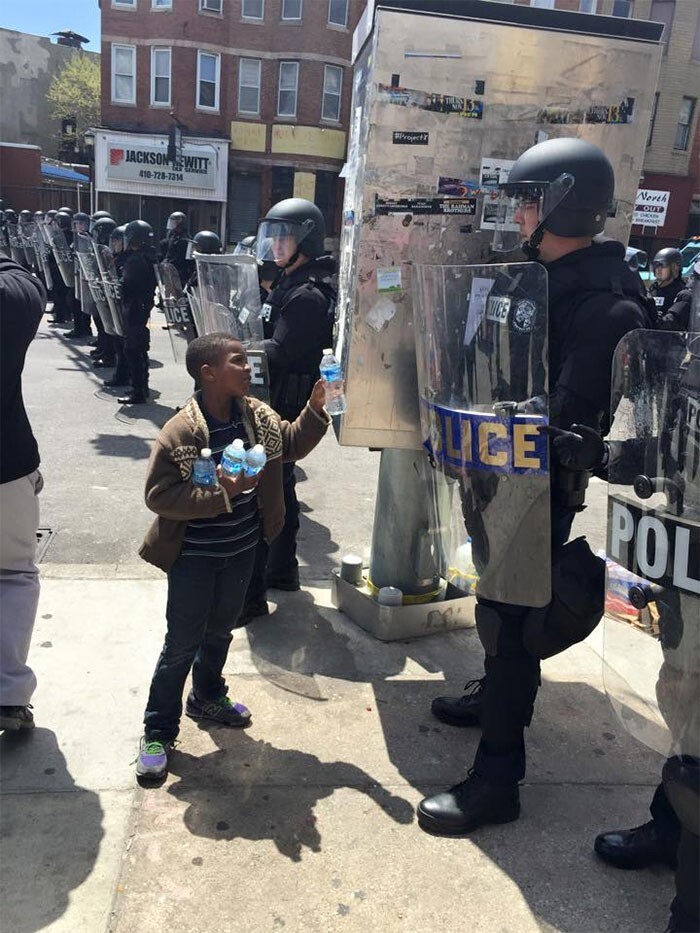 Во время беспорядков в Балтиморе. Мальчик предлагает полицейским воду в жаркий день