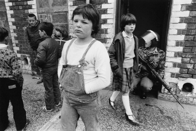 Дети гуляют среди британского патруля во время беспорядков в Лондондерри, Северная Ирландия, 1981 г.