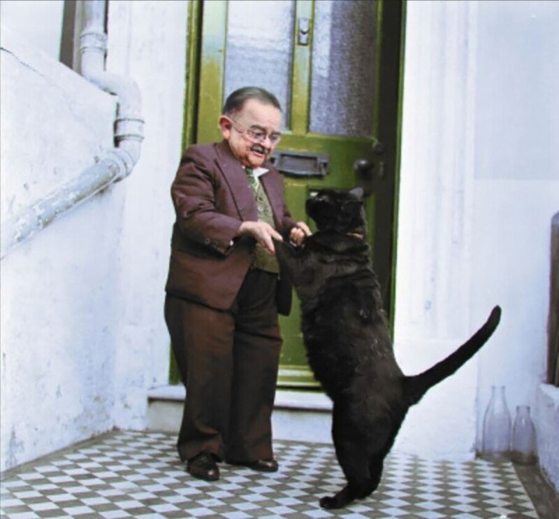  Генри Беренс, самый маленький человек в 1956 году, танцует со своим котом на крыльце дома