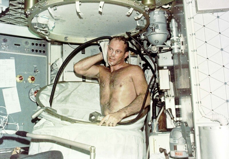 Пилот миссии Skylab 3 Джек Р. Лоусма вытирается полотенцем после вакуумного душа
