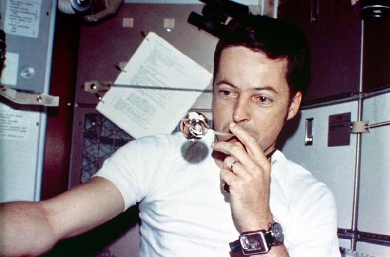 Джозеф Кервин надувает пузырь воды через соломинку во время первой пилотируемой миссии Skylab