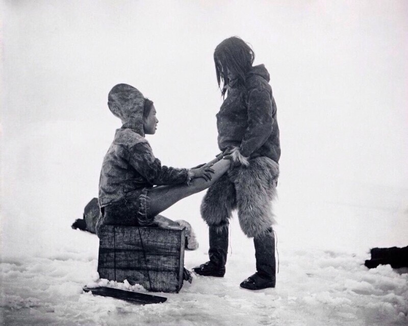 Мужчина-инуит согревает ноги жены. Гренландия, 1880-1890-е. Фото — Роберт Пири