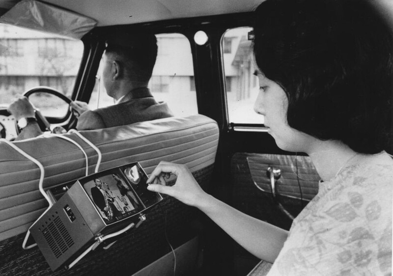 Япония, Токио, 1963 год Женщина смотрит портативный телевизор SONY (модель TV5-303) в автомобиле.