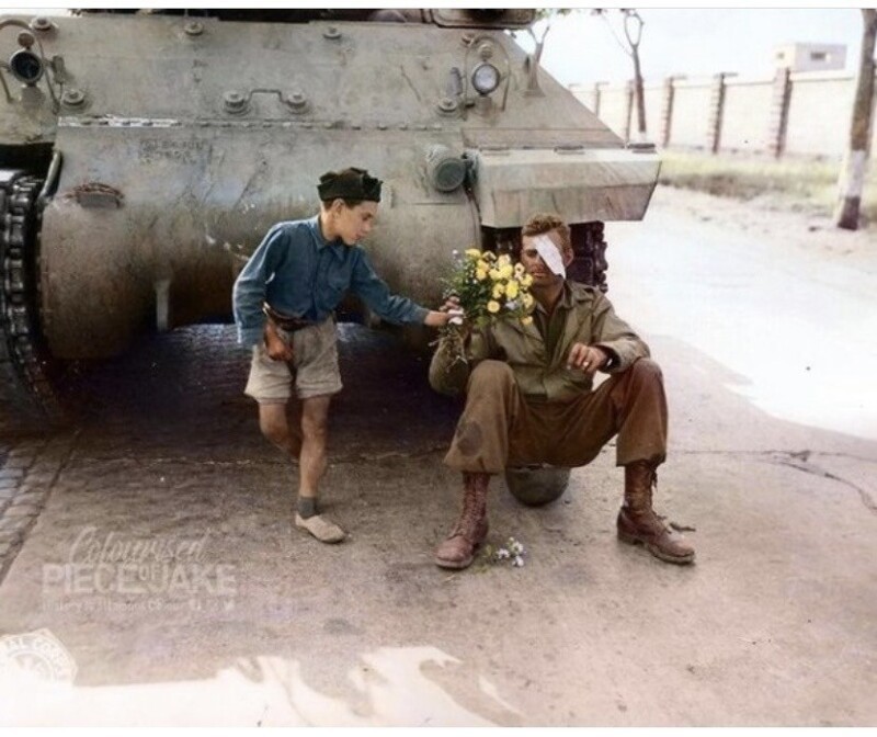 Итальянский мальчик дарит букет цветов американскому солдату , чей танк остановился на въезде в Рим . Июнь , 1944 год