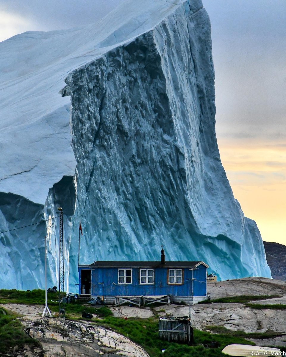 В антураже проплывающего у берега айсберга гренландский дом выглядит кукольным