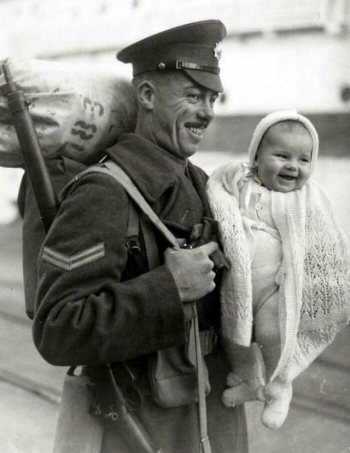 27. Возвращение домой. Британский солдат со своей 8-месячной дочерью на причале после возвращения из-за границы, 1945 год