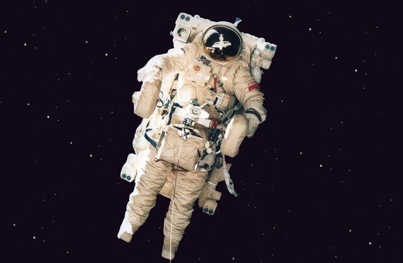 Космонавт Александр Серебров на космическом мотоцикле у станции "Мир".