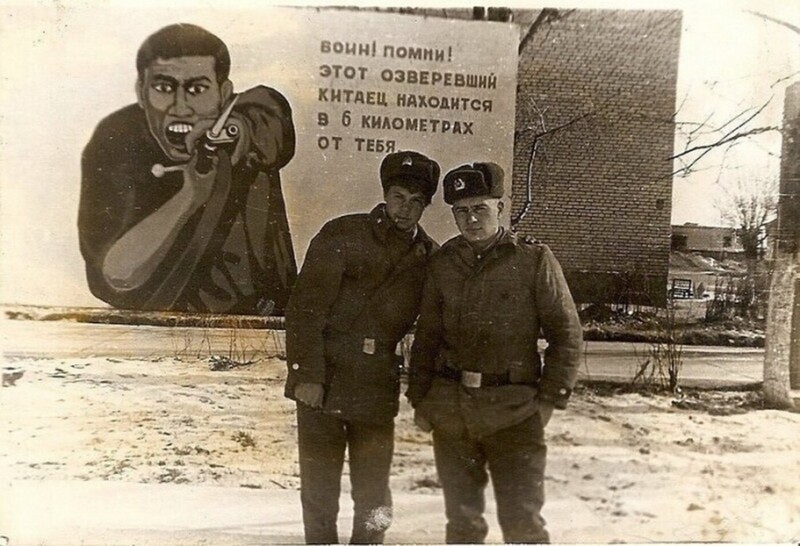 Военнослужащие советской армии у здания с плакатом «Воин! Помни! Этот озверевший китаец находится в 6 км от тебя». Забайкальский Военный Округ, 39-я армия. Монголия. 1986-1988 гг.