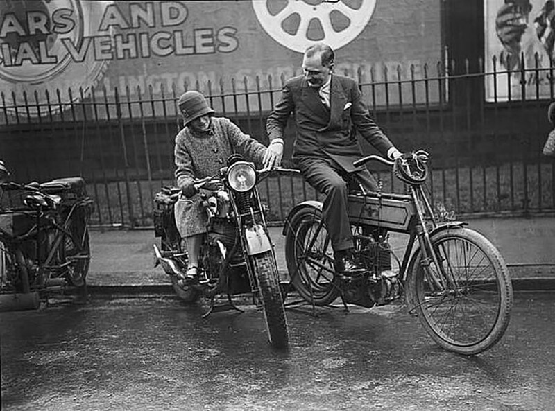 Мисс Эллен Уилкинсон, член парламента (1891-1947) и продавец мотоциклов Кэй Дон (1891-1981) обсуждают мотоциклы Matchless 1930 и 1902 годов на просмотре лондонской выставки мотоциклов в Олимпии 29 ноября 1929 года.