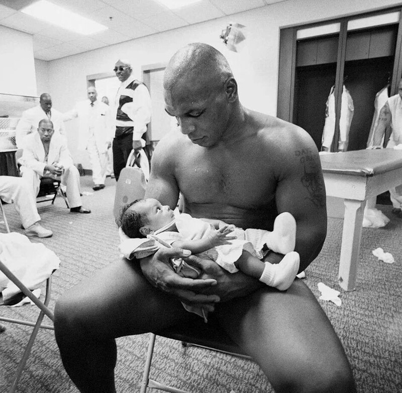 Тайсон держит двухмесячного сына Мигеля в своей раздевалке после того, как проиграл Ленноксу Льюису нокаутом в 8–м раунде, 8 июня 2002 года.