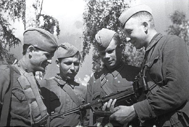 Младший командир демонстрирует красноармейцам трофейный немецкий пистолет-пулемёт MP-38