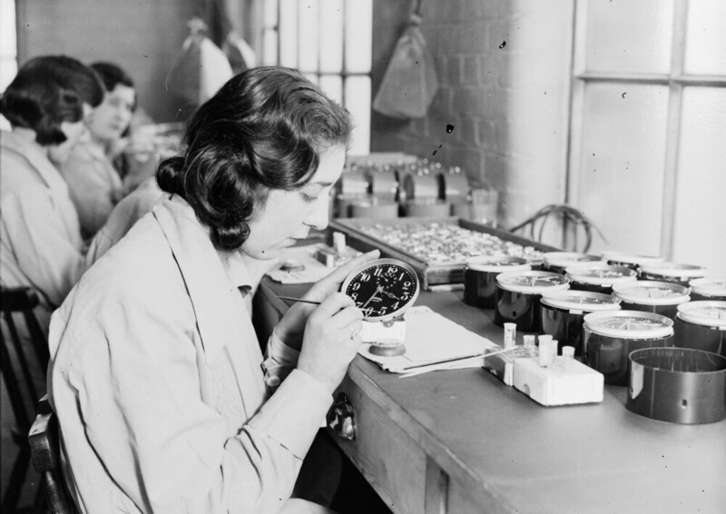 Девушка рисует циферблат часов краской, содержащей соли радия. Фабрика Ингерсол. Январь 1932