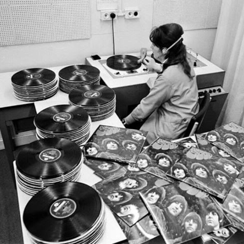 Женщина прослушивает партию пластинок The Beatles в комнате контроля качества фабрики EMI, 1965 год, Великобритания