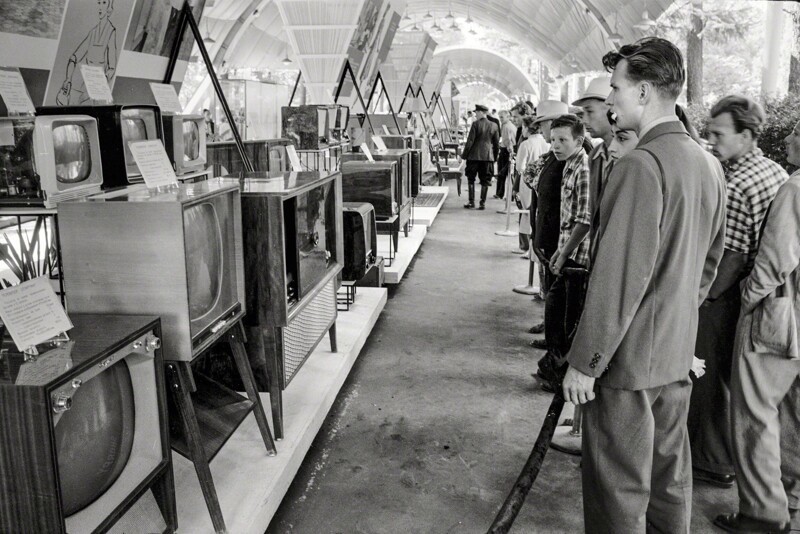 Москвичи рассматривают ассортимент советских телевизоров и радиоприемников представленных на временной выставке в Сокольниках, проходящей одновременно рядом с Американской национальной выставкой, Москва, 1959 год