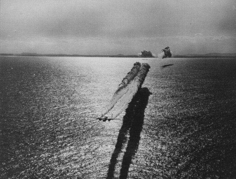 Американский бомбардировщик North American B-25 Mitchell ставит дымовую завесу, которая должна обеспечить скрытность подхода группы американских ударных самолётов для атаки по японским береговым объектам; Тихоокеанский ТВД; 1943-1945 гг