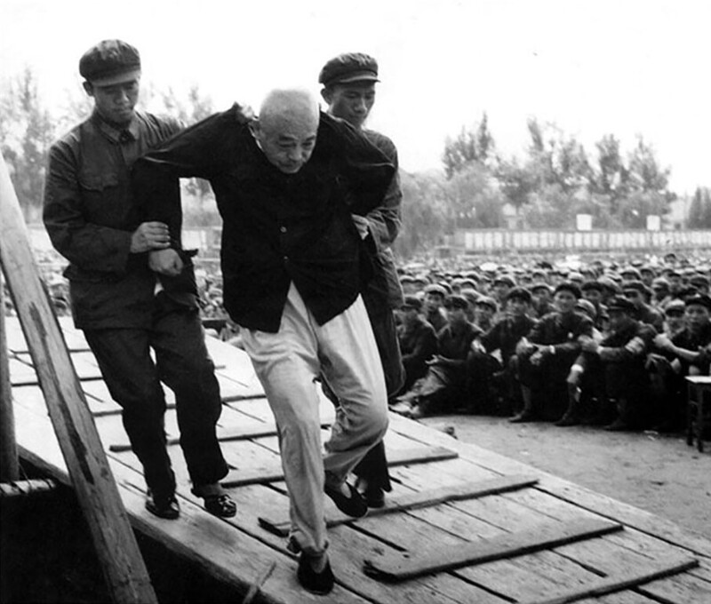 Китайского маршала Пэн Дэхуая хунвэйбины ведут на публичную церемонию унижения как контрреволюционера во время Культурной революции. Пекин. 1966 год