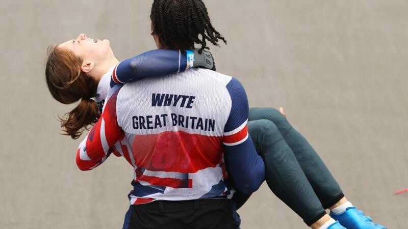 Ассистентка команды несет на руках велосипедистку Бетани Шривер из сборной Британии после того, как та выиграла золотую медаль