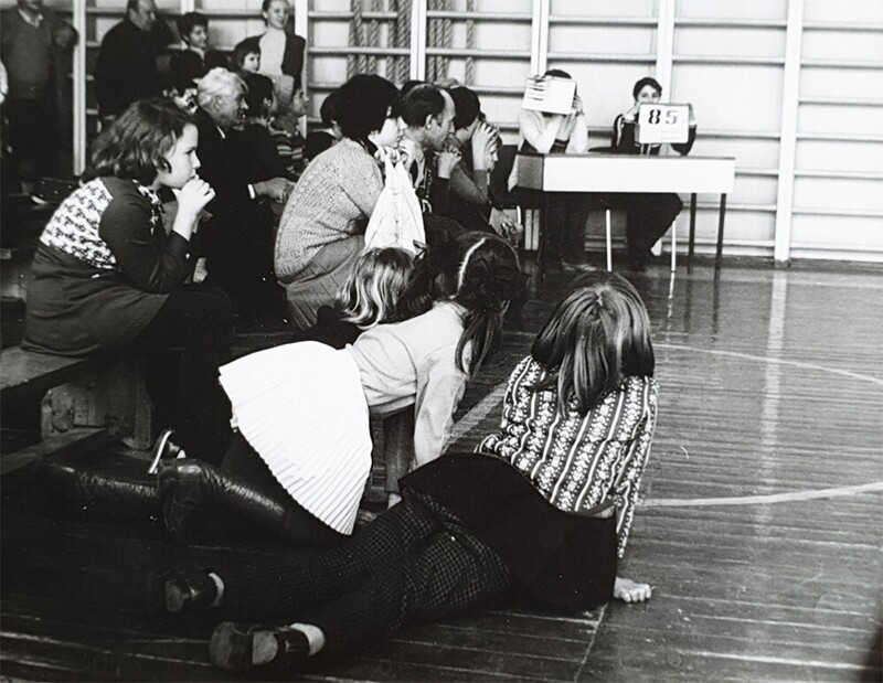 Ноябрь 1979-го, Москва, соревнования в одной из детских спортивных секций по художественной гимнастике. Болельщики в момент выставления оценок после очередного выступления юной гимнастки