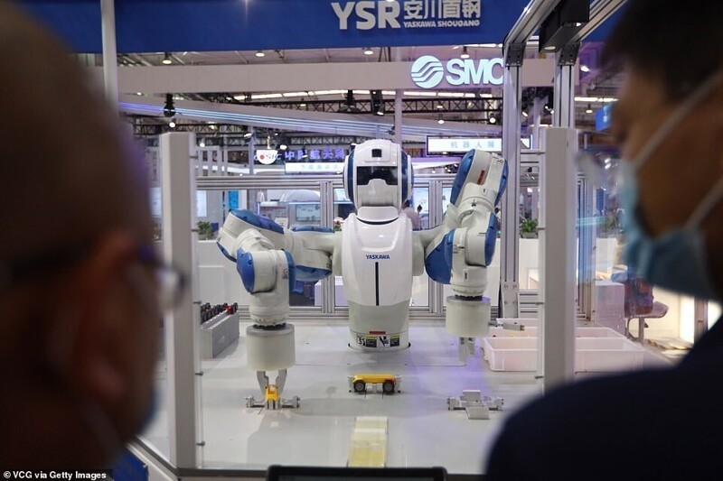 Посетители восхищаются интеллектуальной роботизированной сборочной системой на стенде Yaskawa Shougang Robot Co