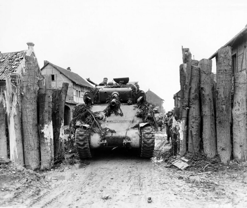 Американский средний танк М4А2 из состава 745-го отдельного танкового батальона проезжает через баррикаду на улицах немецкого города Гладбах; март 1945-го года