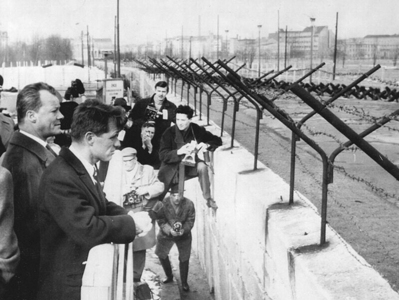 Роберт Кеннеди вместе с мэром Западного Берлина Вилли Брандтом смотрят через Берлинскую стену на территорию ГДР. 22 февраля 1962 год