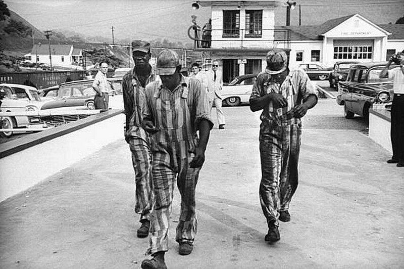 Афро-американские заключенные идут по улице.