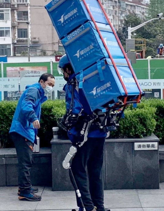 Доставщик использует экзоскелет, чтобы носить тяжелые коробки