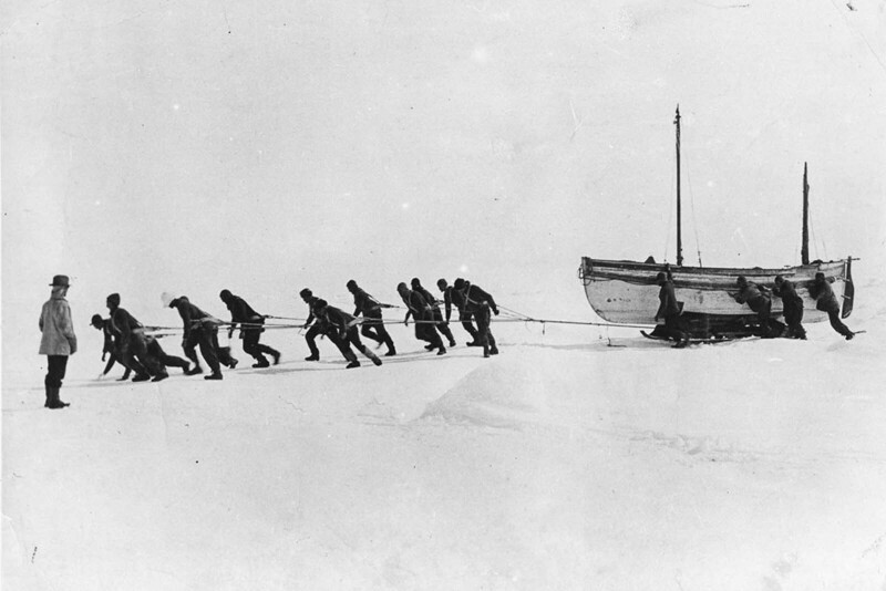 Члены экипажа тянут одну из спасательных шлюпок по льду после потери корабля