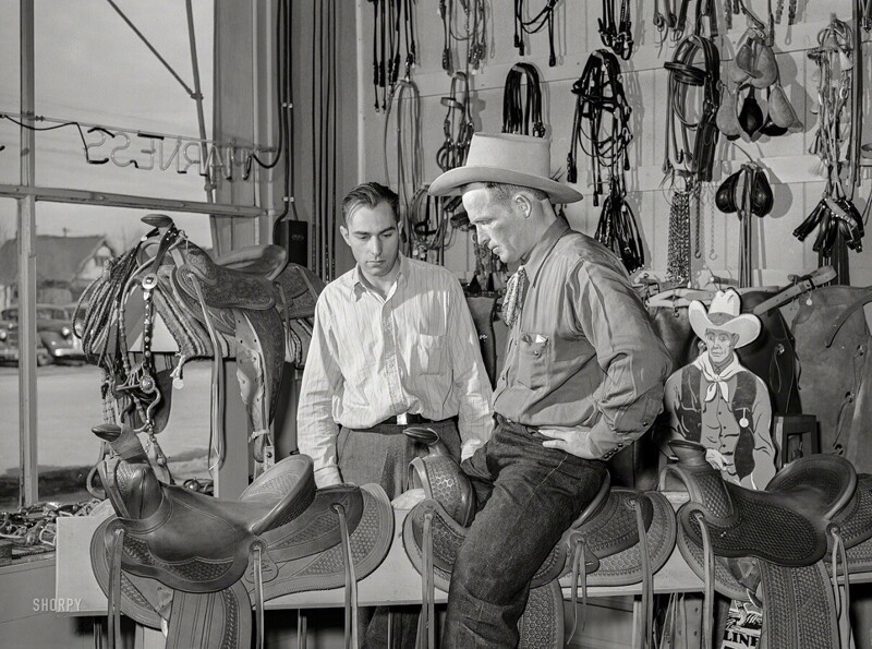 Ковбой выбирает седло в магазине в Элко (штат Невада, США), март 1940 года